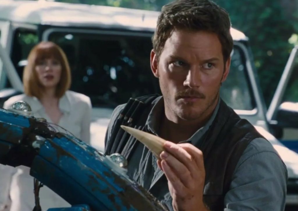 Актер Крис Прэтт (Chris Pratt) держит зуб динозавра.