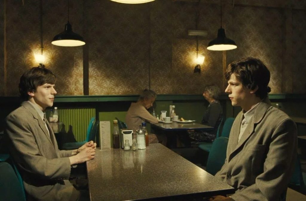 Актер Джесси Айзенберг и его двойник сидят за столом