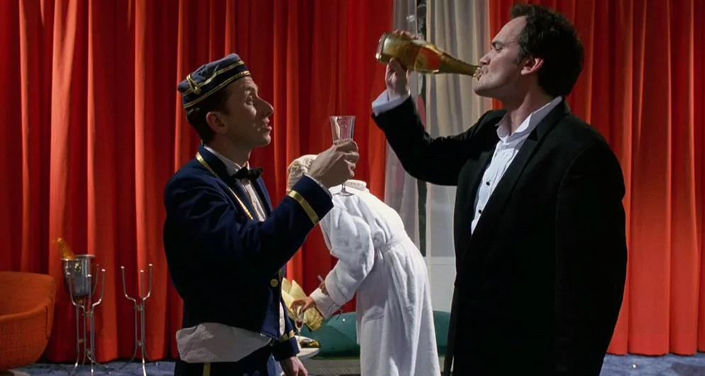 Режиссер Квентин Тарантино пьет шампанское вместе с актером Тимом Ротом.